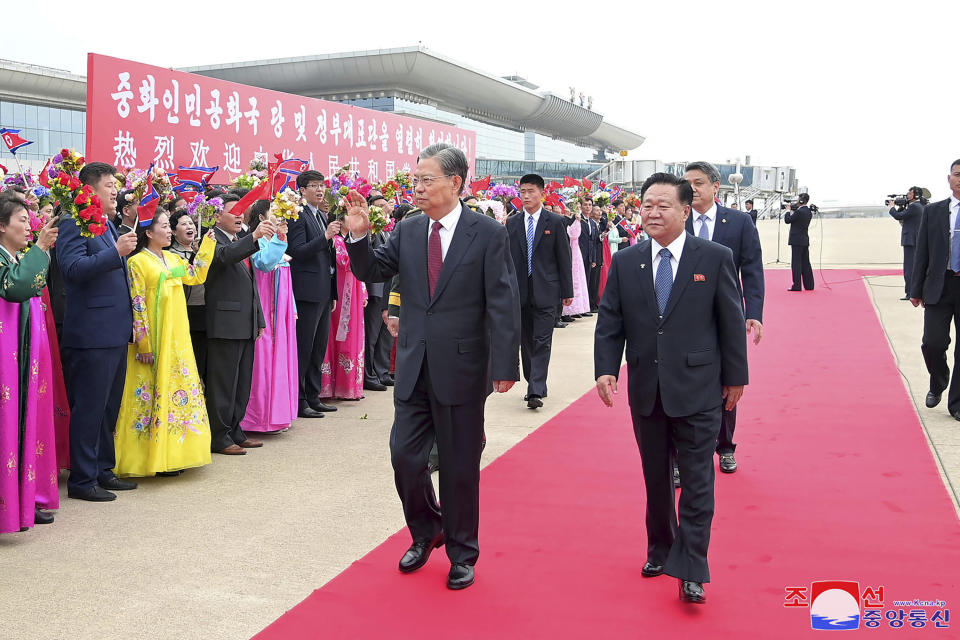 In this photo provided on April 12, 2024, by the North Korean government, Zhao Leji, center, chairman of the National People’s Congress of China waves, escorted by Choe Ryong Hae, right, vice-chairman of the central committee of the Workers' Party of North Korea, as Zhao arrived at Pyongyang International Airport in Pyongyang, North Korea, on April 11, 2024. Korean language watermark on image as provided by source reads: "KCNA" which is the abbreviation for Korean Central News Agency.(Korean Central News Agency/Korea News Service via AP)