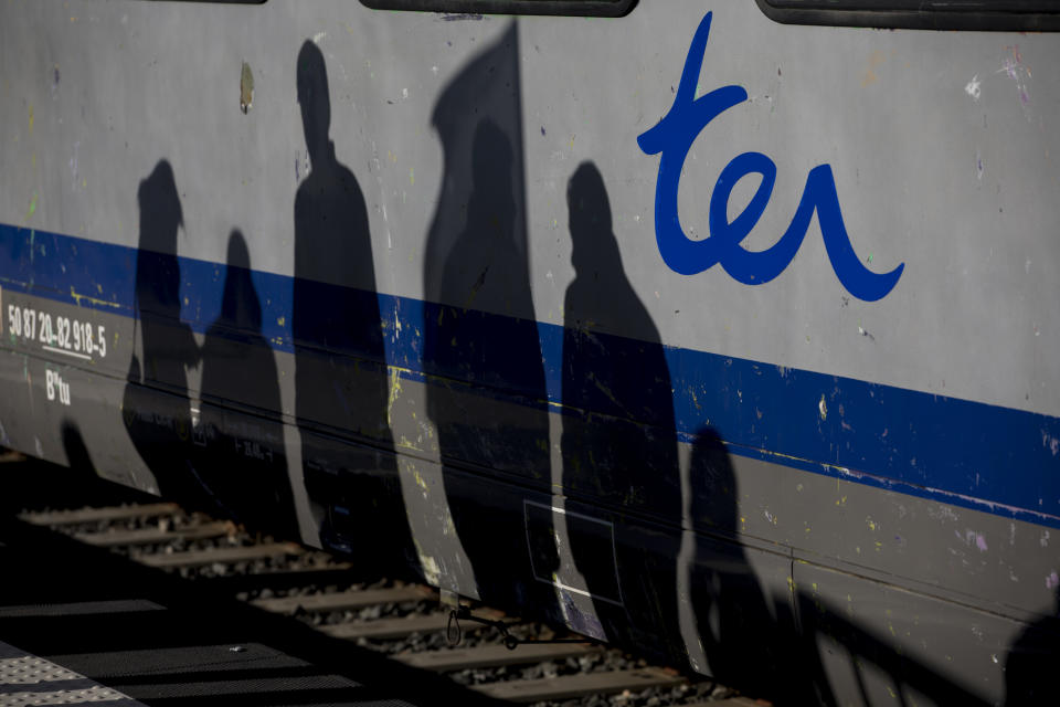 The shadows of railway workers are cast on a regional line train during a union general assembly meeting at the Gare St-Charles station in Marseille, southern France, Monday, Dec. 9, 2019. Paris commuters inched to work Monday through exceptional traffic jams, as strikes to preserve retirement rights halted trains and subways for a fifth straight day. (AP Photo/Daniel Cole)