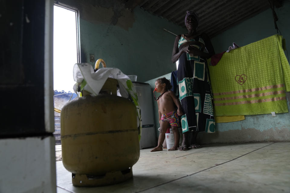 Lady Laurentino, 74, stands near an empty cooking gas cylinder at her home in Jardim Gramacho favela of Rio de Janeiro, Brazil, Monday, Oct. 4, 2021. Laurentino says she is cooking with wood because she doesn't have money to buy another gas cylinder. (AP Photo/Silvia Izquierdo)