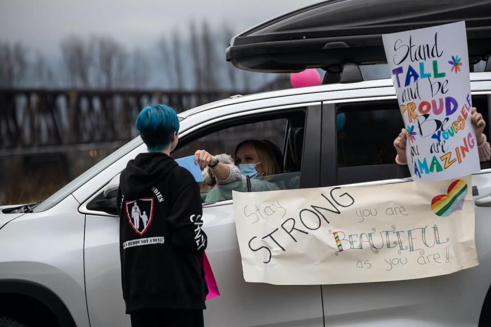 A teenager receives a card from a motorist during an anti-bullying parade in Mission, B.C., Jan. 17, 2021. THE CANADIAN PRESS/Darryl Dyck