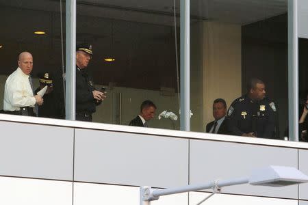 Boston Police officers, including Commissioner William Evans (C), work inside the building where a shooting occurred at Brigham and Women's hospital in Boston, Massachusetts January 20, 2015. REUTERS/Brian Snyder