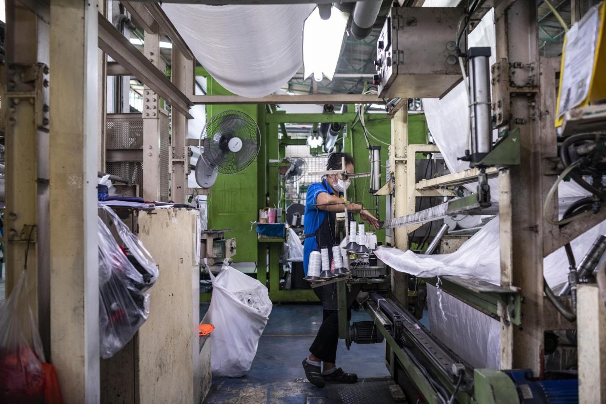 A factory employee handles fabric made from recycled plastic bottles at a Thai Taffeta Co. factory in Rayong, Thailand, on Friday, Oct. 22, 2021. Photographer: Andre Malerba/Bloomberg