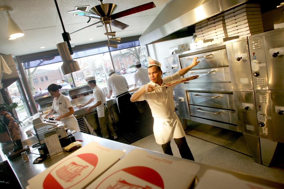 Pagliai's Nang Nguyen rotates and serves pizza during dinner rush, April 28, 2011.