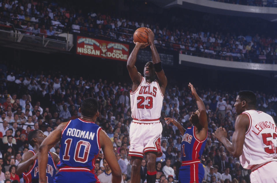 Michael Jordan #23 of the Chicago Bulls jumps to shoot a basket against the Detroit Pistons as Cliff Levingston #53 of the Bulls, Dennis Rodman #10 of the Pistons and Isiah Thomas #11 of the Pistons watch the shot at the Chicago Stadium during the 1991 NBA Playoffs in Chicago, Illinois. (Photo by Focus on Sport via Getty Images)