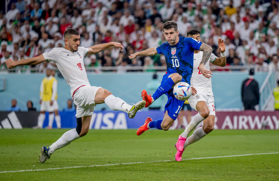 DOHA, QATAR - NOVEMBER 29: Christian Pulisic (C) of USA scores his team's first goal past Majid Hosseini (L) and Amir Abedzadeh of Iran during the FIFA World Cup Qatar 2022 Group B match between IR Iran and USA at Al Thumama Stadium on November 29, 2022 in Doha, Qatar. (Photo by Marvin Ibo Guengoer - GES Sportfoto/Getty Images)