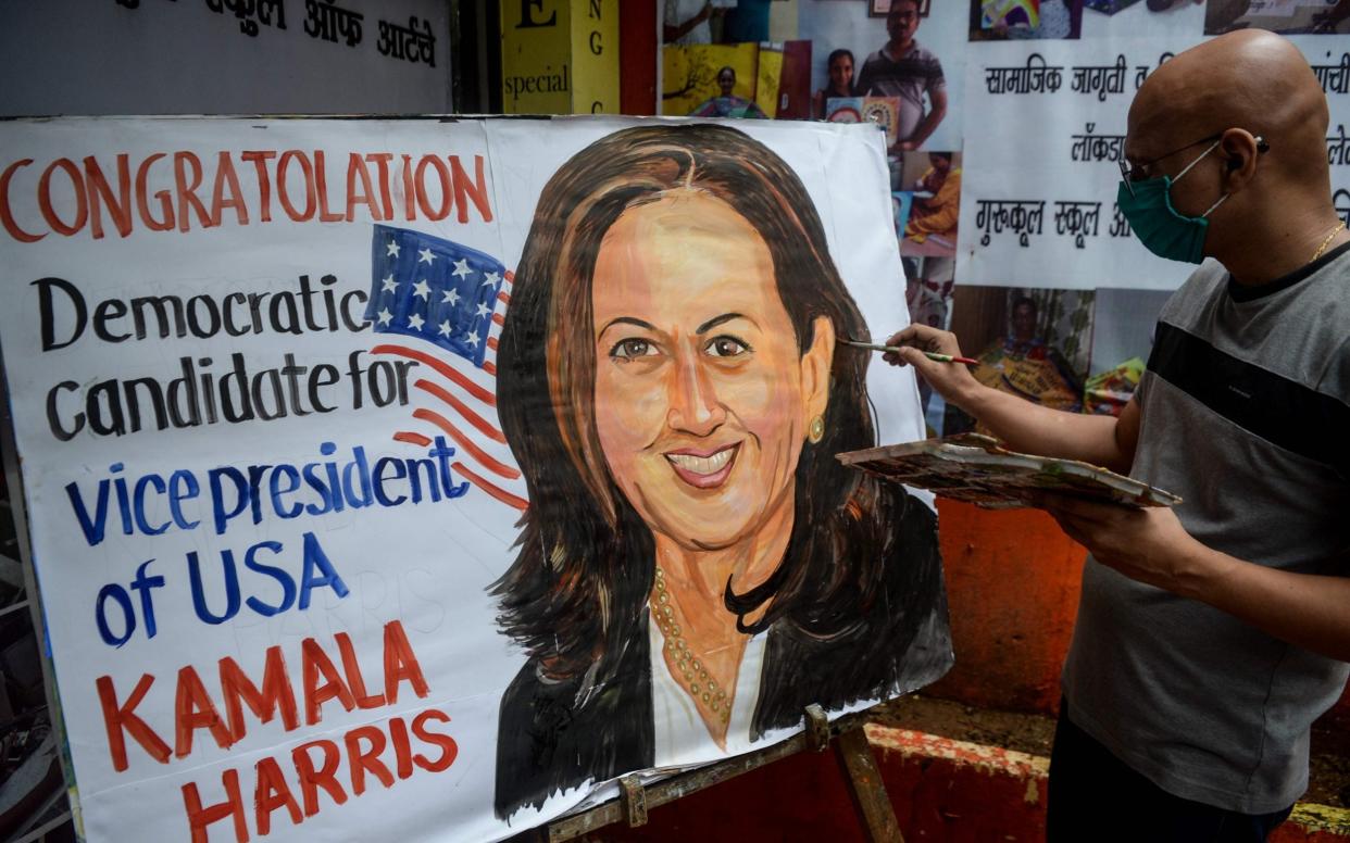 An art enthusiast paints on a canvas the face of presumptive US Democratic Vice President nominee Kamala Harris outside a drawing school in Mumbai  - AFP