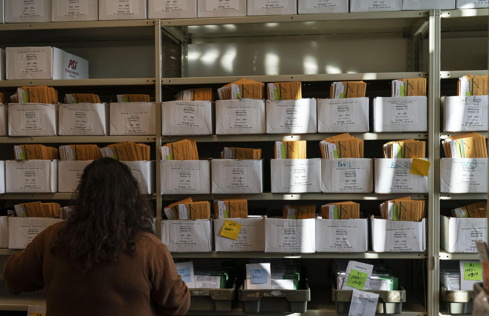 Election worker Madison Takala organizes ballots ahead of Tuesday's general election at the city clerk office in Warren, Mich., Wednesday, Oct. 28, 2020. (AP Photo/David Goldman)