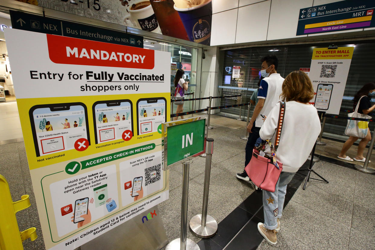 Fully vaccinated shoppers enter a shopping mall on November 20, 2021 in Singapore. (Photo by Suhaimi Abdullah/NurPhoto via Getty Images)