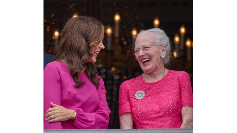 Queen Mary and Queen Margrethe laughing on the balcony