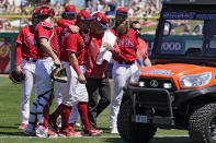 Philadelphia Phillies first baseman Rhys Hoskins, center, is helped by teammates to an awaiting cart after he was injured fielding a ground ball by Detroit Tigers' Austin Meadows during the second inning of a spring training baseball game Thursday, March 23, 2023, in Clearwater, Fla. (AP Photo/Chris O'Meara)