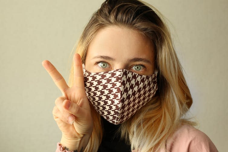 A woman wearing a chequered reusable cloth mask.