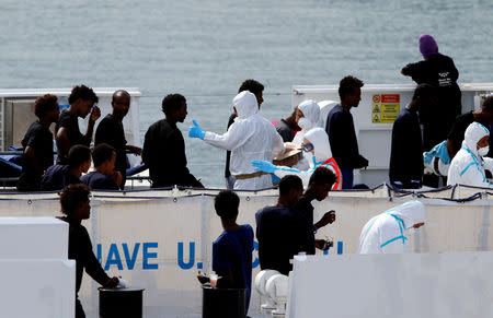 FILE PHOTO: Migrants wait to disembark from the Italian coast guard vessel "Diciotti" at the port of Catania, Italy, August 22, 2018. REUTERS/Antonio Parrinello/File Photo