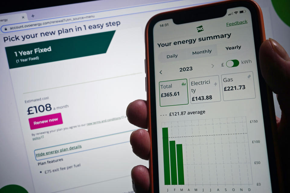 The OVO Energy app on a mobile phone is held against a laptop screen displaying details of a one-year fixed rate OVO Energy tariff for customers as the supplier has offered its first deal below the Government's £2,500 cap on typical household bills amid falling wholesale gas prices. The energy giant is offering a one-year fixed tariff of £2,275 to existing customers - undercutting the Government's energy price guarantee (EPG). Picture date: Sunday March 26, 2023. (Photo by Yui Mok/PA Images via Getty Images)