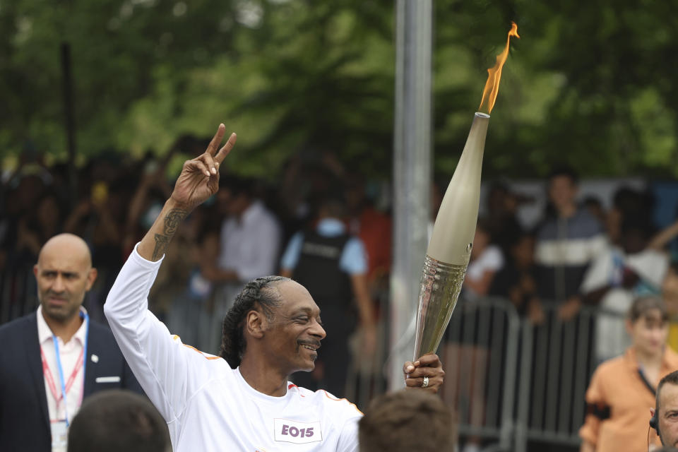 Snoop Dogg carries the Olympic torch before opening ceremony in Paris