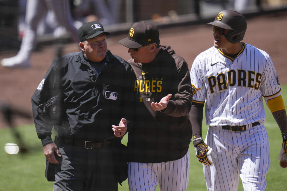 San Diego Padres manager Bob Melvin, center, talks with home plate umpire Ron Kulpa, left, as Manny Machado, right, is thrown out of the game after being called out on an automatic strike during the first inning of a baseball game against the Arizona Diamondbacks, Tuesday, April 4, 2023, in San Diego. (AP Photo/Gregory Bull)
