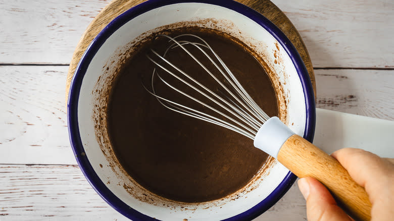 Hand whisking hot chocolate in saucepan