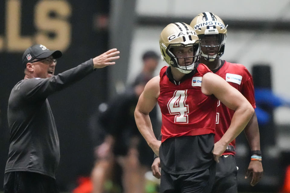 New Orleans Saints offensive coordinator Pete Carmichael instructs quarterbacks Derek Carr (4) and Jameis Winston during an NFL football practice in Metairie, La., Tuesday, May 30, 2023. (AP Photo/Gerald Herbert)