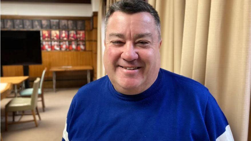 Kevin Small smiling while standing in council room