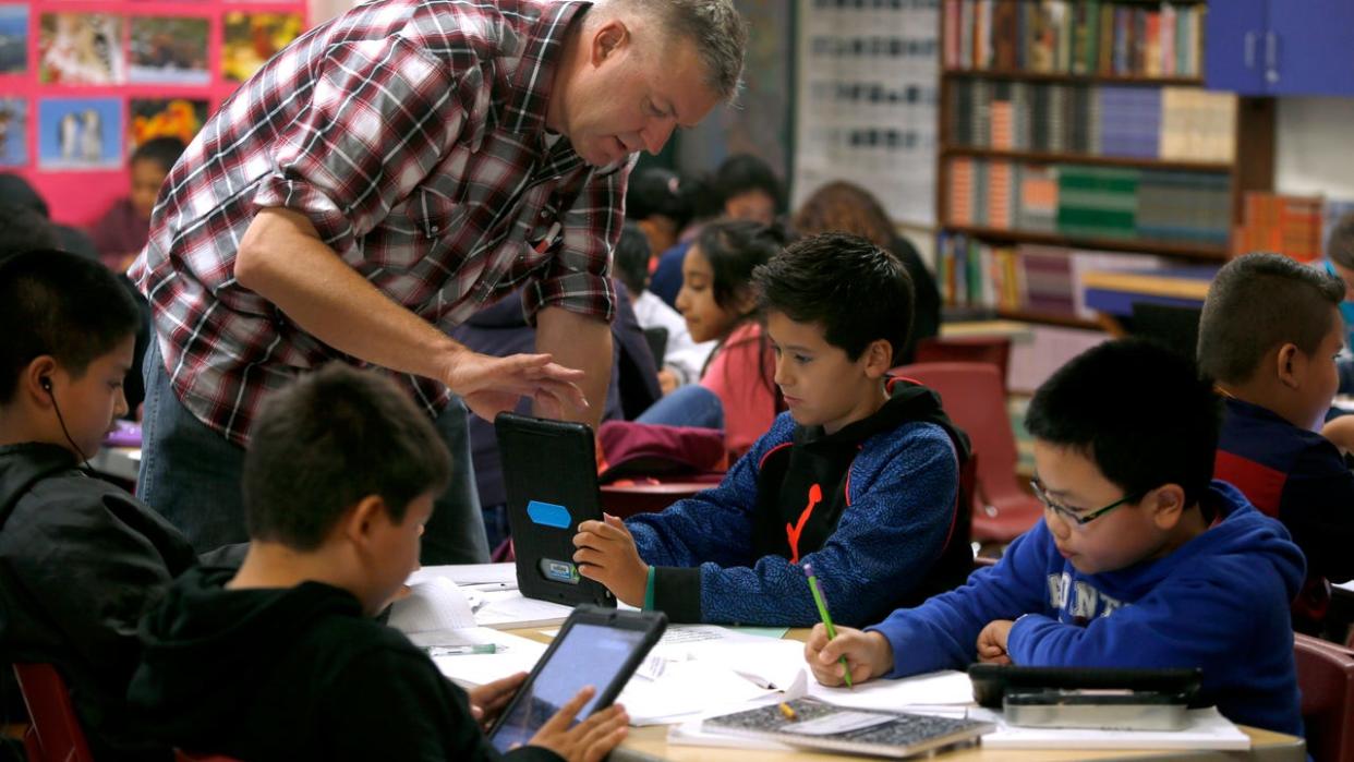 <div>Teacher helps a student with his classroom-issued iPad. (Photo By Paul Chinn/The San Francisco Chronicle via Getty Images)</div>