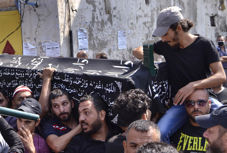 FILE - In this Sept. 25, 2020 file photo, Lebanese Mohammed Sufian, top right, tries to view the body of his 2½-year-old son Sufian, as other relatives and friends carry his coffin during the funeral procession of two children who passed away earlier this month as a result of severe heat with no food or water while on a boat with their parents attempting to migrate to Cyprus, in Tripoli, north Lebanon. On Monday, Dec. 7, 2020, the United Nations Children’s Fund launched a global appeal for a record $2.5 billion of emergency assistance for the Middle East and North Africa, saying the funds were necessary to respond to the needs of millions of children across a region hit hard by conflict, natural disaster and the coronavirus crisis. (AP Photo, File)