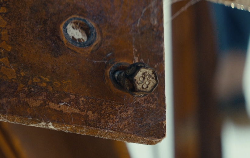 A loose bolt on a rusty ladder