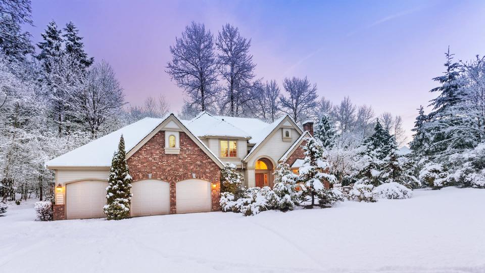 Daylight fades over a snow-covered suburban home - Image.