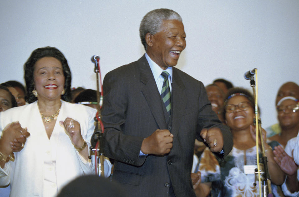FILE - Nelson Mandela, and Coretta Scott King, left, widow of slain civil rights leader Martin Luther King, Jr., sing and dance at a victory celebration for Mandela in Johannesburg, on May 2, 1994, after Mandela and the ANC appeared to take the majority of the votes in the country's first integrated elections. The South African government announced Friday Jan. 19, 2024 that it plans to challenge an auction of artifacts which belonged to Mandela, set to take place in New York next month. (AP Photo/David Brauchli, File)