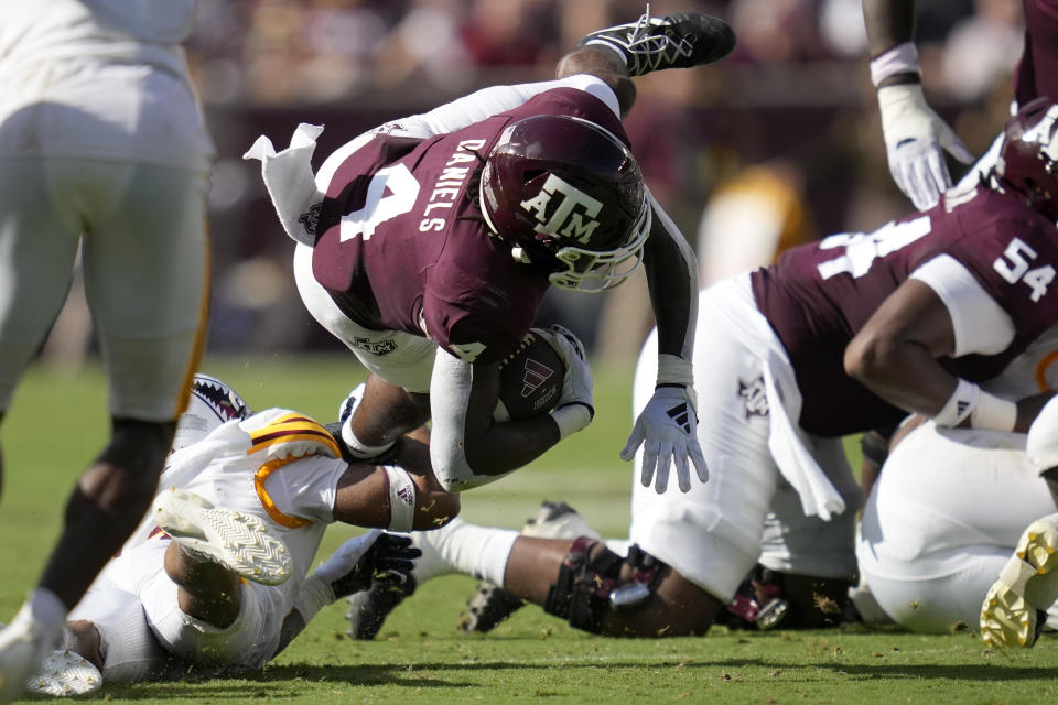 Texas A&M running back Amari Daniels (4) is stopped short of a first down by Louisiana-Monroe safety Lynard Harris, bottom left, during the second quarter of an NCAA college football game Saturday, Sept. 16, 2023, in College Station, Texas. (AP Photo/Sam Craft)