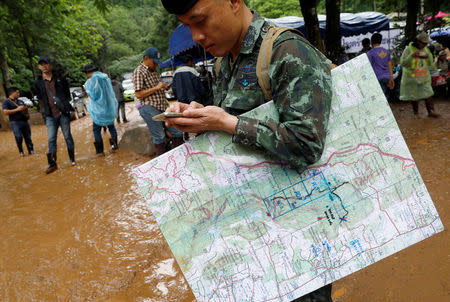 A soldier hold a map as he works near the Tham Luang cave complex during a search for members of an under-16 soccer team and their coach, in the northern province of Chiang Rai, Thailand, June 27, 2018. REUTERS/Soe Zeya Tun