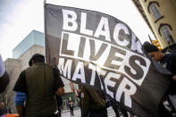 David Brown carries a Black Lives Matter flag during a march through downtown Grand Rapids, Mich., on Saturday, April 23, 2022. The march, which was organized by the Breonna Taylor Foundation, began at Veterans Park in response to the shooting death of Patrick Lyoya by a Grand Rapids police officer on April 4. (Daniel Shular/The Grand Rapids Press via AP)