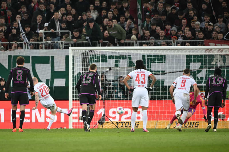Bayern Munich goalkeeper Manuel Neuer (2nd R) catches the ball from a penalty kick by Augsburg's Sven Michel (2nd L) during the German Bundesliga soccer match between FC Augsburg and Bayern Munich at the WWK-Arena. Sven Hoppe/dpa