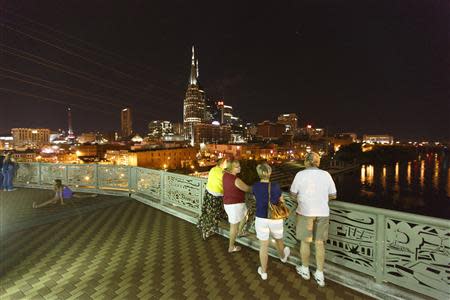 Visitors enjoy an evening walk over the Shelby Street Pedestrian Bridge and take in the view of the skyline in downtown Nashville, Tennessee June 18 2013. REUTERS/Harrison McClary