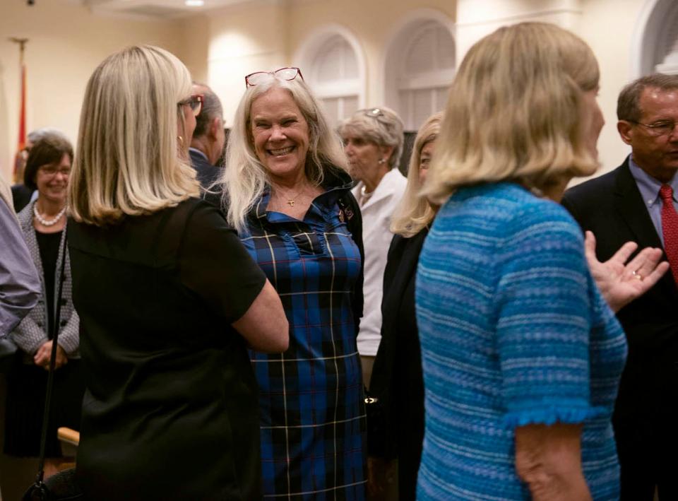 Julie Araskog, second from left, smiles as she greets residents Tuesday after accepting her nomination to the Town Council at the Town Caucus.