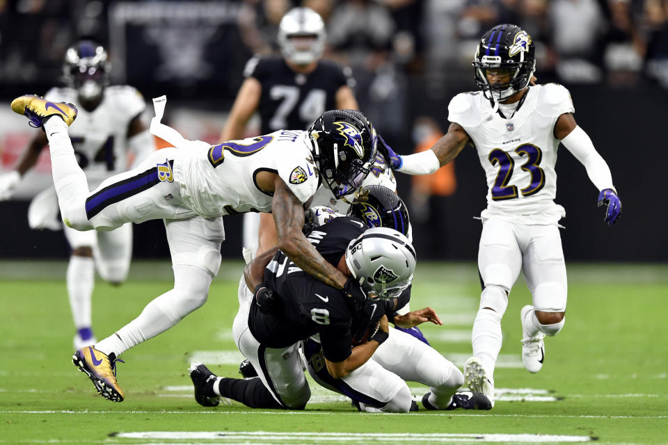 Marcus Mariota of the Las Vegas Raiders is tackled by DeShon Elliott of the Baltimore Ravens