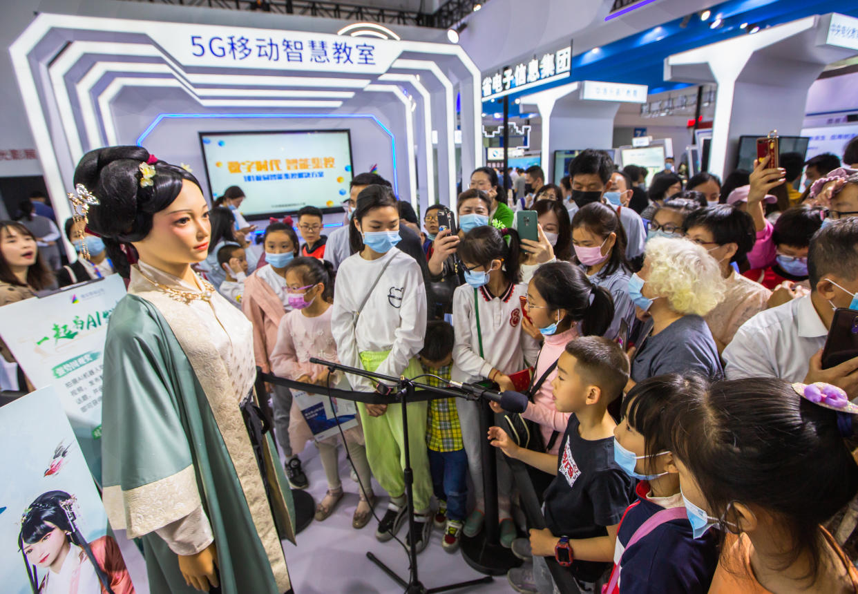 Los visitantes observan un robot de inteligencia artificial que smula a la poeta de la dinastía Song, Li Qingzhao, durante la 4ta Cumbre de China Digital en el Centro Internacional de Exposiciones y Conferencias del Estrecho de Fuzhou el 26 de abril de 2021 en Fuzhou, provincia china de Fujian. (Foto de Yang Enuo/VCG vía Getty Images)