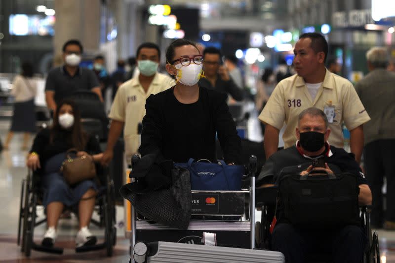 Passengers are seen wearing protective face masks as they arrive at Suvarnabhumi Airport in Bangkok