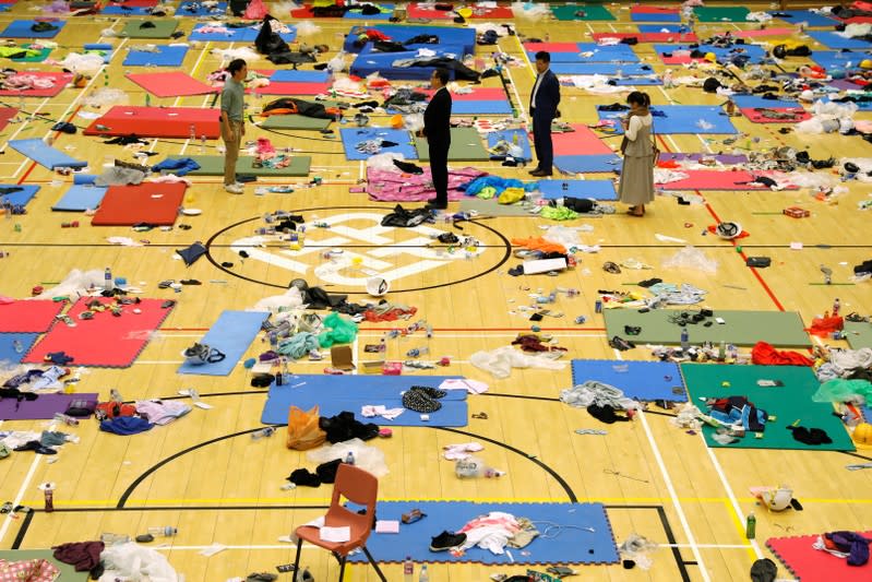 Pro-democratic lawmakers stand amidst the items left behind by protestors in Hong Kong Polytechnic University (PolyU) in Hong Kong, China