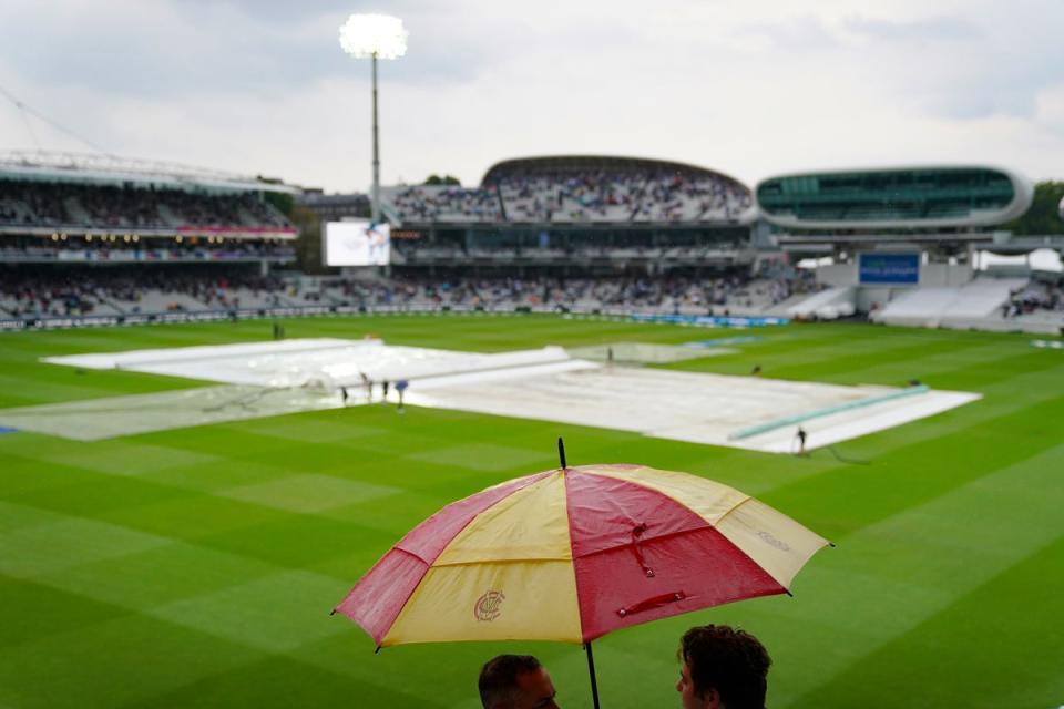 Spectators put up umbrellas as rain stops play during day one at Lord’s (Adam Davy/PA) (PA Wire)