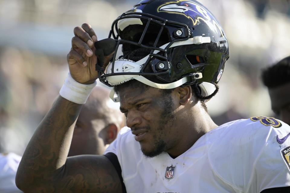 Ravens quarterback Lamar Jackson (8) pushes up his helmet as he leaves the field.