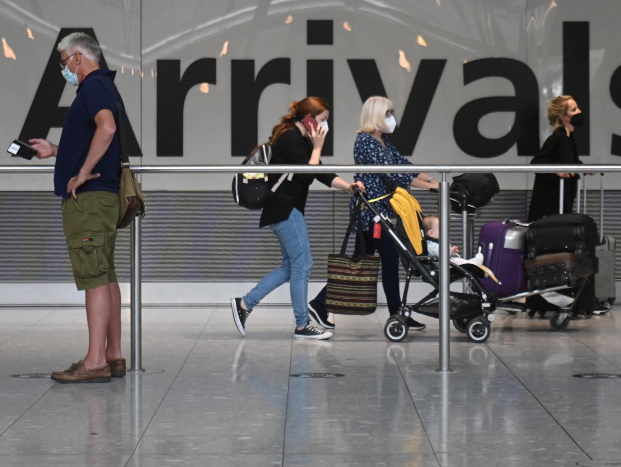 <p>Passengers push their luggage on arrival in Terminal 5 at Heathrow airport in London, on June 3, 2021</p> (AFP via Getty Images)