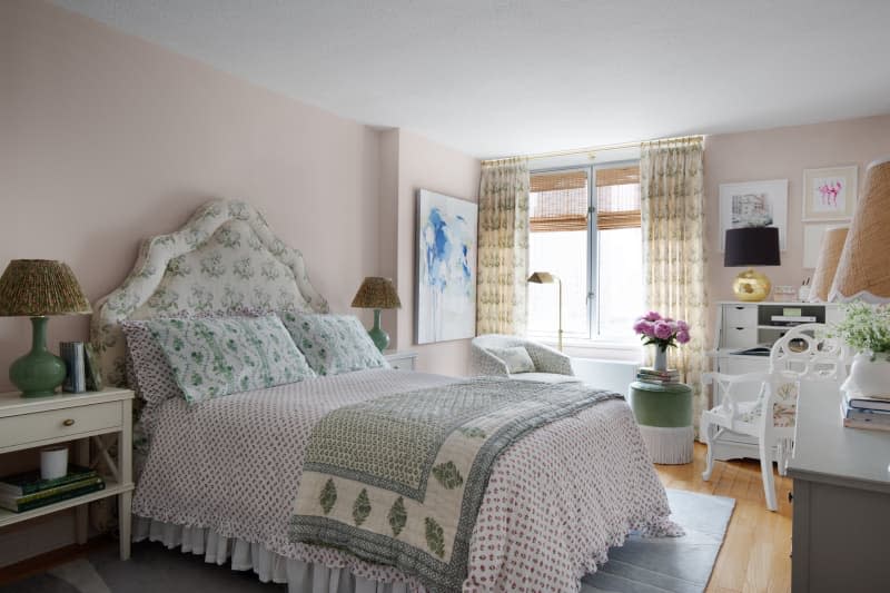 Fabric peak headboard with matching pillows, floor to ceiling curtains, green base lamps with pleated shades on matching white nightstands