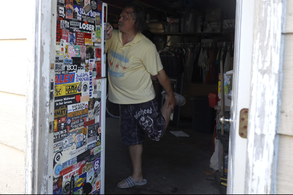 Dan O'Conor stretches his leg due to minor knee pain before his 365th plunge into Lake Michigan, Saturday, June 12, 2021, at his home in Chicago's Lincoln Park. (AP Photo/Shafkat Anowar)