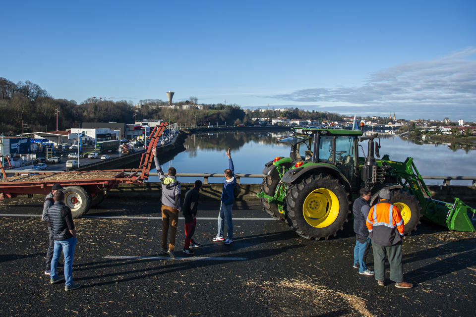 French farmers block the Hubert Touya viaduct on a highway Tuesday, Jan. 23, 2024 in Bayonne, southwestern France. Farmers have for months been protesting for better pay and against what they consider to be excessive regulation, mounting costs and other problems. (AP Photo/Nicolas Mollo)