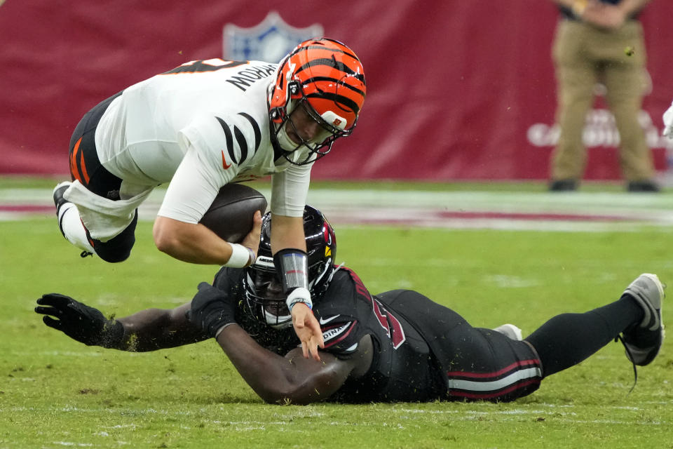 Cincinnati Bengals quarterback Joe Burrow, left, is tackled by Arizona Cardinals defensive tackle Carlos Watkins during the second half of an NFL football game, Sunday, Oct. 8, 2023, in Glendale, Ariz. (AP Photo/Rick Scuteri)