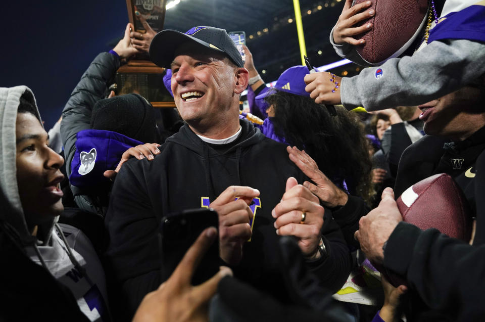 FILE - Washington head coach Kalen DeBoer is surrounded by fans rushing the field after a win over Washington State after an NCAA college football gam,e Saturday, Nov. 25, 2023, in Seattle. Washington won 24-21. (AP Photo/Lindsey Wasson, File)