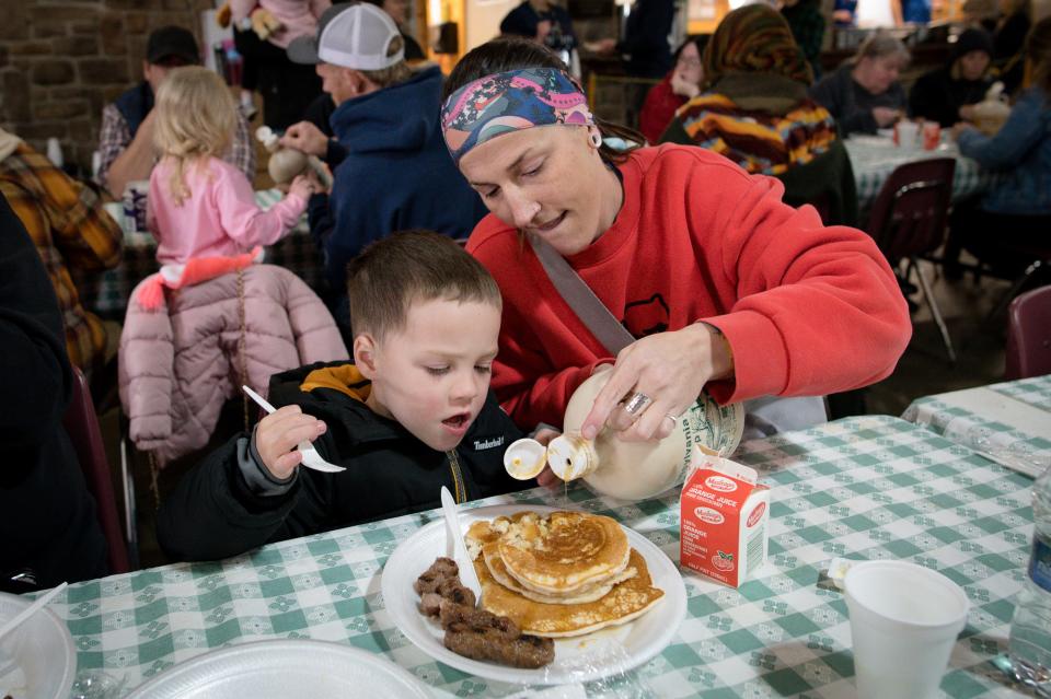 Karla Beatty pours syrup for her nephew, Jameson Follmar, 4, during the Maple Syrup Festival Sunday at Bradys Run Park.