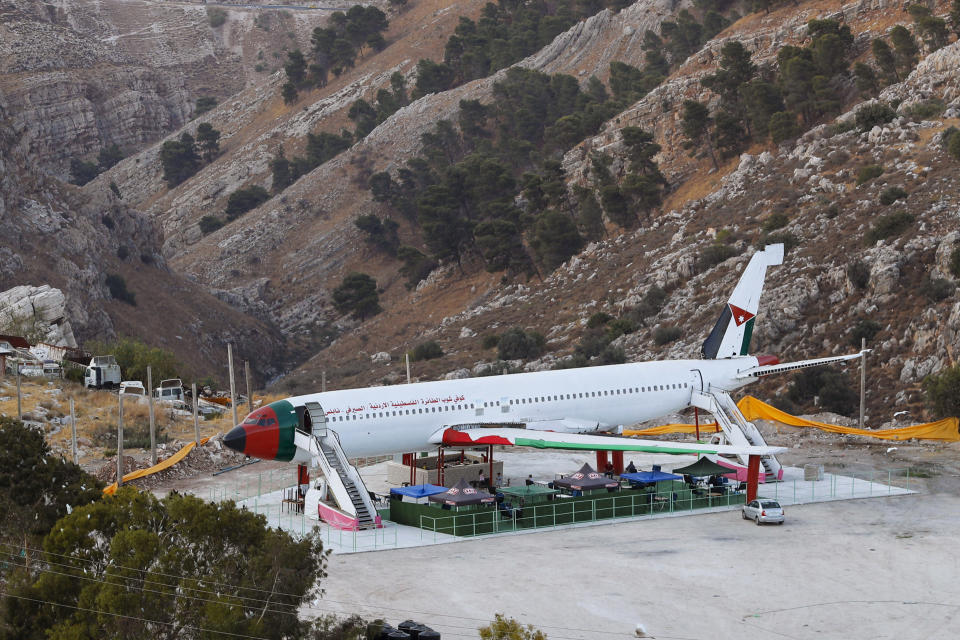 A Boeing 707 aircraft has been converted to a cafe, in Wadi Al-Badhan, just outside the West Bank city of Nablus, Aug. 11, 2021. Few Palestinians in the occupied West Bank get to board an airplane these days. The territory has no civilian airport and those who can afford a plane ticket must catch their flights in neighboring Jordan. But twins brothers, Khamis al-Sairafi and Ata, are offering people the old airplane for customers to board. (AP Photo/Majdi Mohammed)