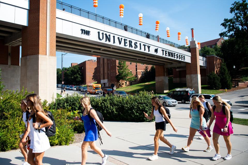 Students walk by the pedestrian bridge as they head to class during the first day of the fall semester on the University of Tennessee's campus.