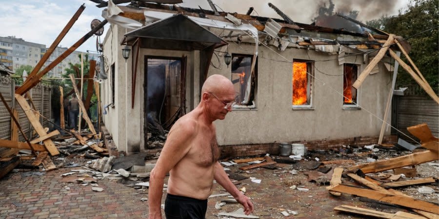 A resident of Lysychansk against the background of a house destroyed by the occupiers