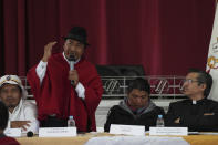 Indigenous leader Leonidas Iza speaks during a dialogue session with the government, with Catholic Church representatives as mediador, at the Episcopal Conference headquarters in Quito, Ecuador, Thursday, June 30, 2022. The two groups are discussing solutions that could lead to the end of a strike over gas prices that has paralyzed parts of the country for two weeks. Sitting, from left, are Indigenous leaders Eustaquio Toala and Marlon Vargas, and Monsignor David de la Torre. (AP Photo/Dolores Ochoa)